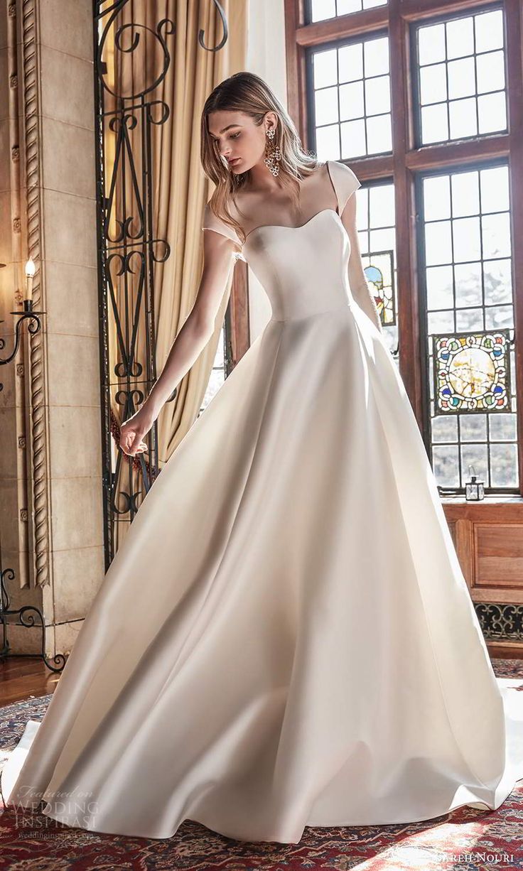 a woman in a wedding dress standing on a rug