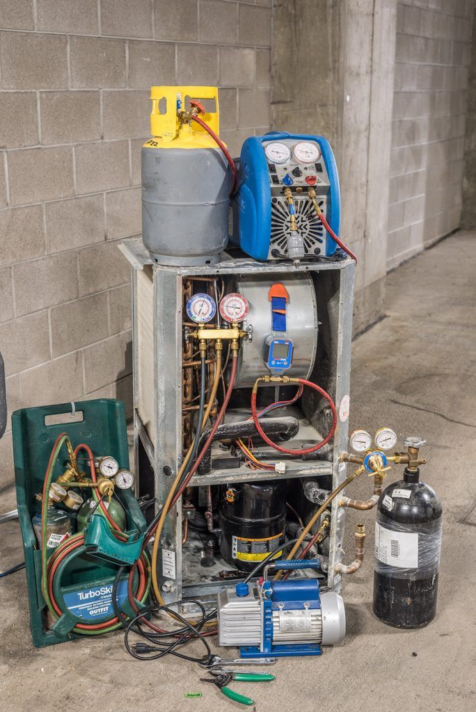 an air conditioner sitting on the side of a building next to some wires and other equipment