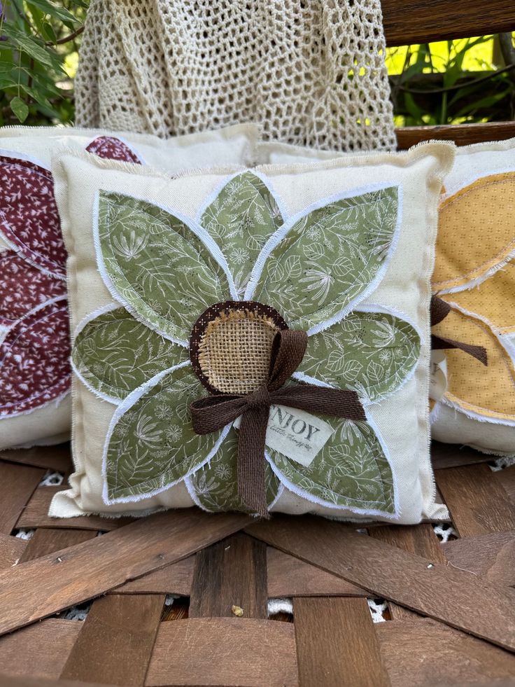 two decorative pillows sitting on top of a wooden table