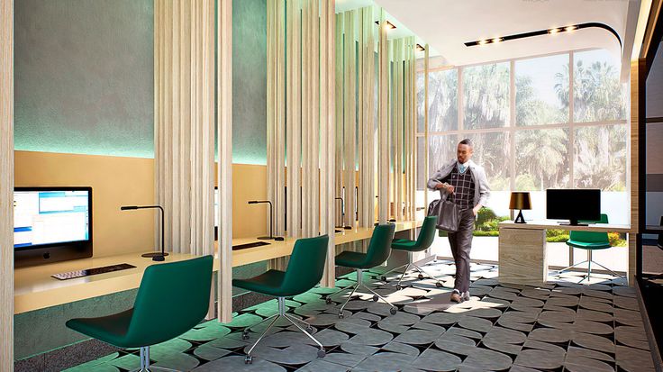 a man is standing in the middle of a room with green chairs and televisions