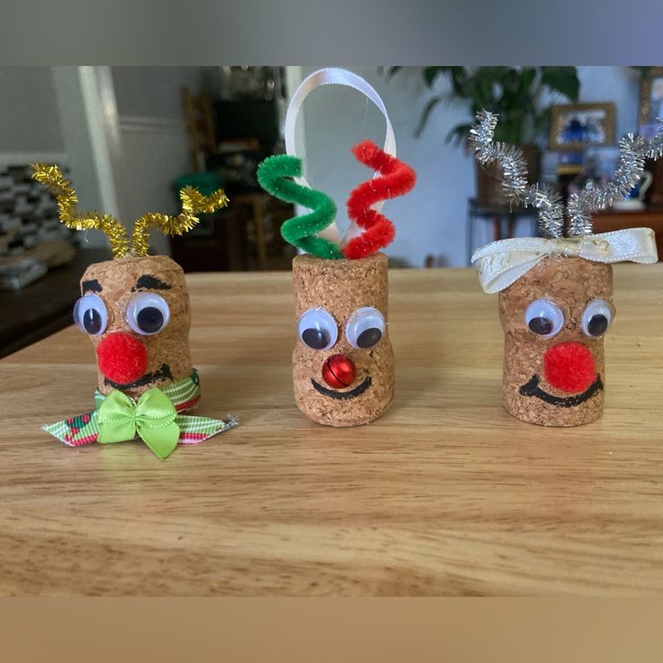 three toilet paper roll reindeers sitting on top of a wooden table next to each other