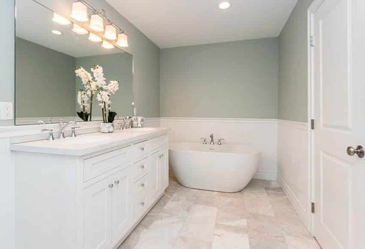 a bathroom with a large white tub next to a walk in shower and two sinks