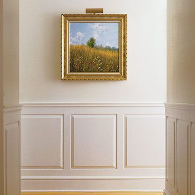 an empty room with a painting hanging on the wall