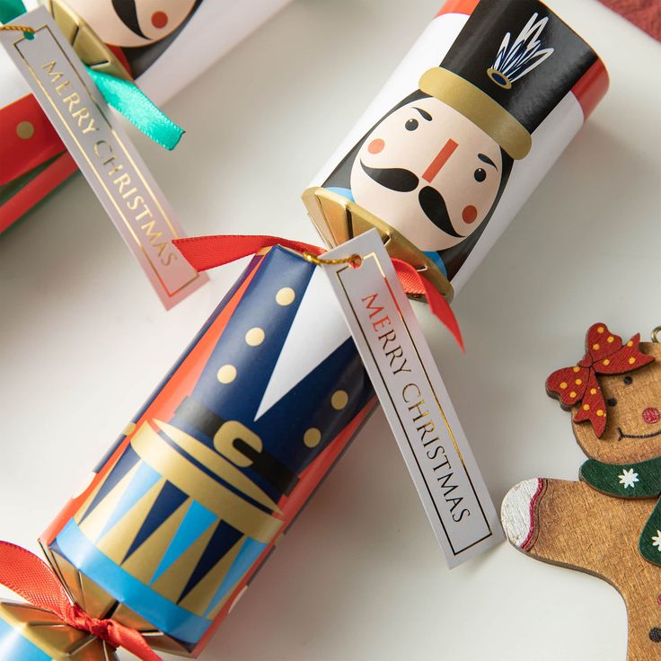 three christmas crackers decorated like nutcrackers with ribbons and tags on them