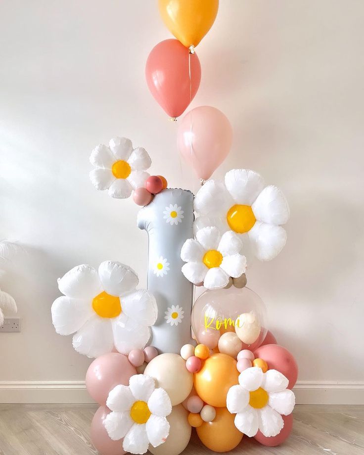 balloons and flowers are arranged in the shape of an i - letter on a wooden floor