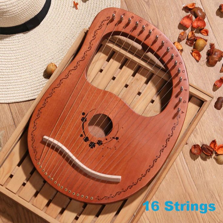 a small wooden instrument sitting on top of a wooden floor next to a straw hat