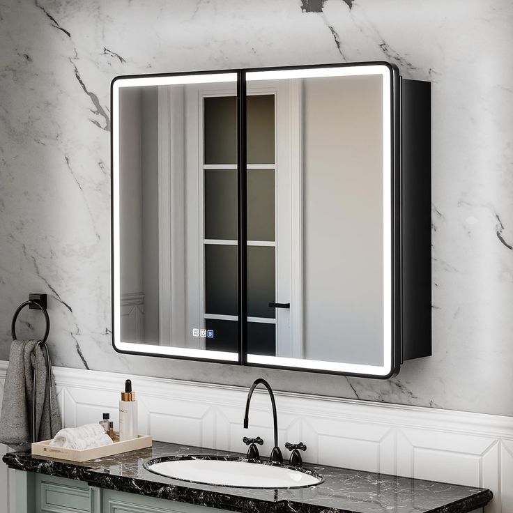 a bathroom with marble counter tops and a large mirror over the sink that's illuminated