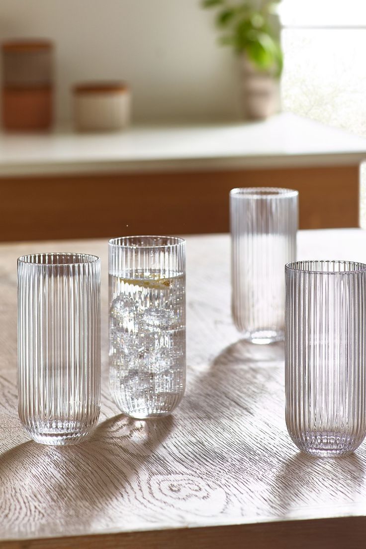 three glass vases sitting on top of a wooden table