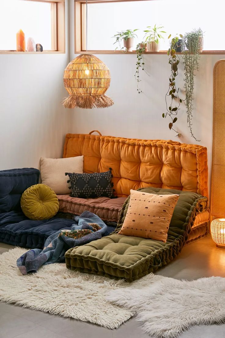 a living room filled with lots of furniture and pillows on top of a white rug