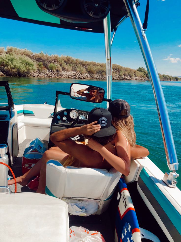 two people sitting on the back of a boat