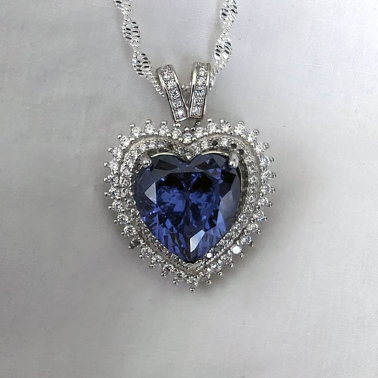 "This gorgeous Sterling Silver cubic zirconia studded Tanzanite heart necklace and earring set would make the perfect classy gift for a bridesmaid, as an anniversary gift, for Valentine's Day or for Mother's Day.  Tanzanite is the birthstone for those born in December, making it a thoughtful birthday gift as well! Pictures were taken both indoor and outdoors to best represent color. ~Measurements~ The heart pendant measures 1\" tall and 3/4\" wide.  The Tanzanite heart stone is 12mm x 12mm.  The Heart Of The Ocean Necklace, Sapphire Heart Necklace, Born In December, Well Pictures, Titanic Jewelry, Tanzanite Necklace, Tanzanite Jewelry, Tanzanite Earrings, Jewelry Heart