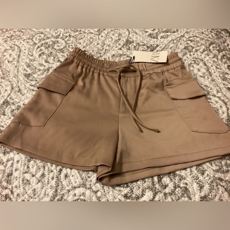 New With Tags Zara Silk Like Polyester Cargo Shorts With Elastic Waist And Front Zipper Closure With Button And Tie Waist. Size Small. Can Be Dressed Up Or Down. Brown Shorts For Day Out, Chic Summer Cargo Shorts With Pockets, Summer Bottoms With Pockets In Brown, Zara Shorts With Pockets For Spring, Zara Shorts With Pockets, Brown Summer Cargo Shorts With Side Pockets, Zara High-waisted Shorts With Pockets, Shorts With Pockets For Day Out, Brown Cargo Shorts For Summer