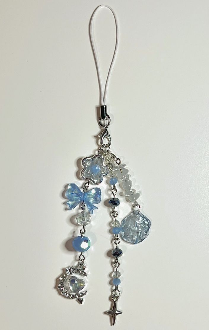 a close up of a key chain with beads and charms hanging from it's end