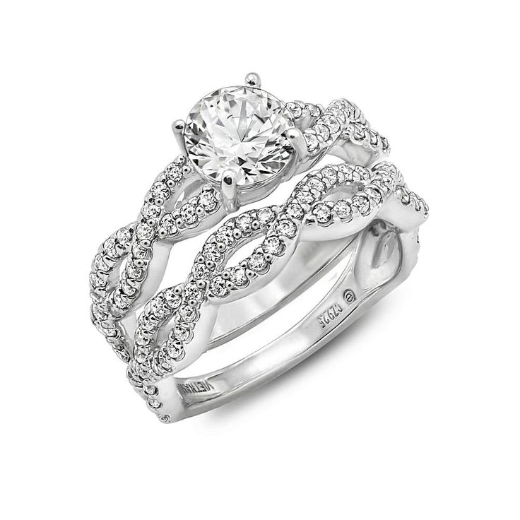 a white gold ring set with diamonds on the sides and an intricate design in the middle