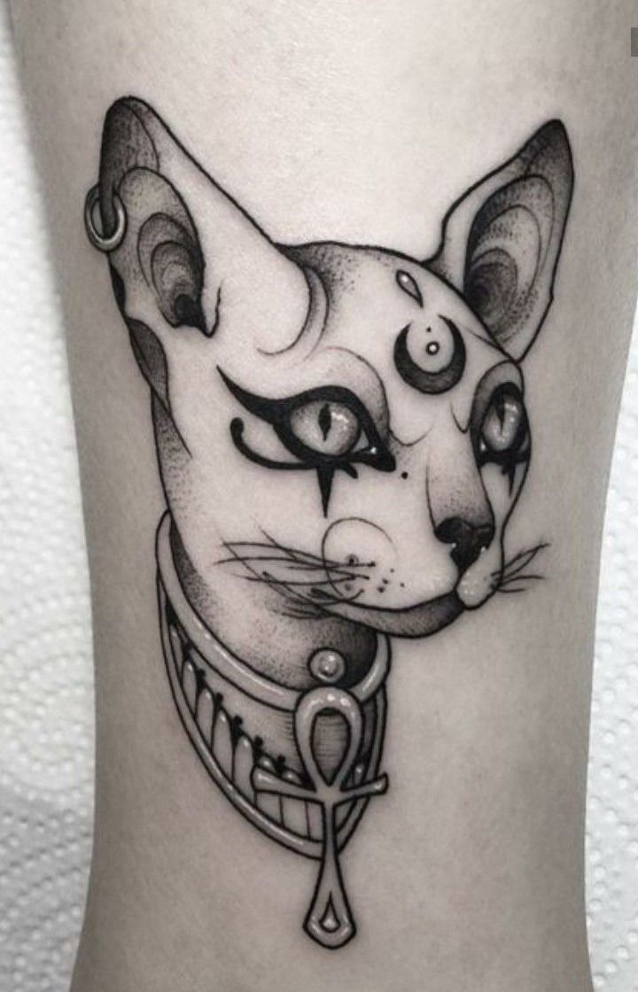 a black and white cat tattoo on the leg with an evil look to it's face