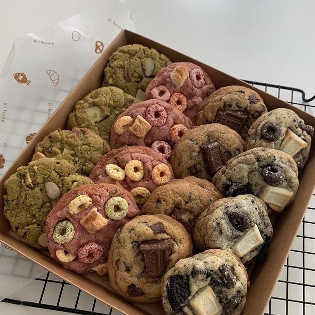 a box filled with assorted cookies on top of a cooling rack