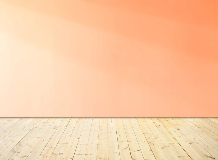 an empty room with wood floor and orange wall in the background, as well as a wooden floor