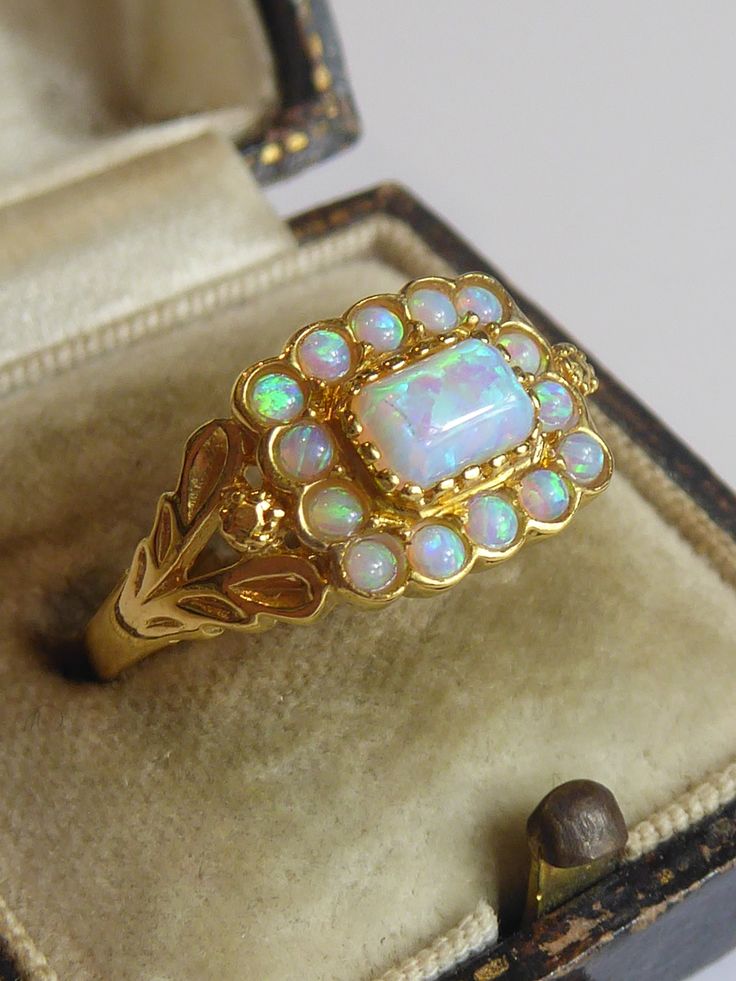 Fine solid silver & 18ct gold plated georgian styled ring. the centre set with an oblong cultured opal surrounded by 14 smaller round cut opals.  has a pretty leaf design at side of shank. ring size uk- o. looks very elegant when worn. front panel measures 9mm high x 11mm wide, marked,sil for silver all tested silver & 18ct gold. Victorian Gold Cluster Ring With Gemstone, Heirloom Gold Opal Cabochon Ring, Heirloom Gold Opal Ring With Cabochon, Vintage Opal Rings In Yellow Gold, Vintage Gold Opal Jewelry, Elegant Gold Opal Cabochon Ring, Vintage Gold Opal Cabochon Ring, Antique Style Opal Ring For Formal Occasions, Antique Gold Opal Ring For Formal Occasions