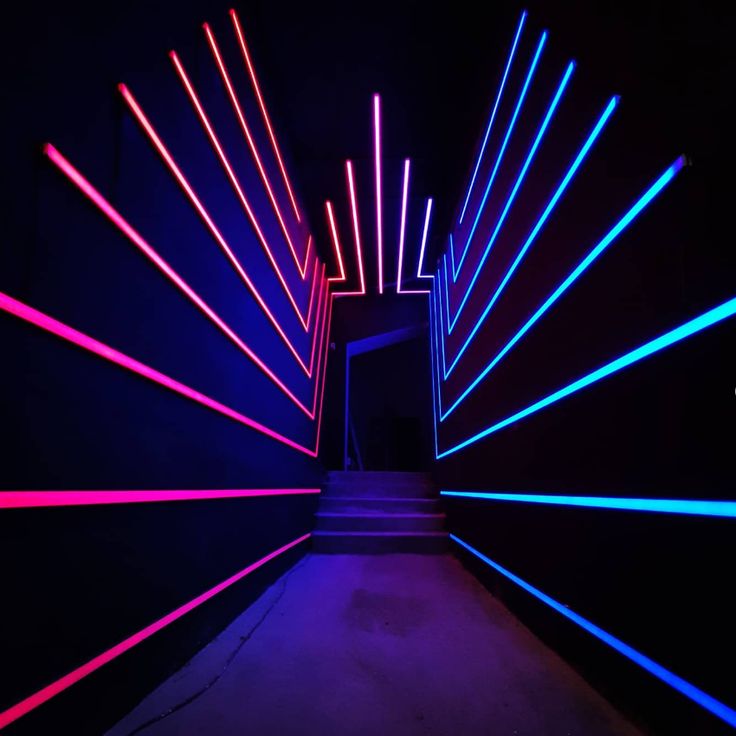 an open doorway with neon lights in the dark, and stairs leading up to it