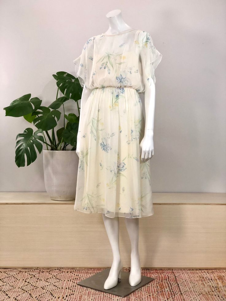 vintage flowy ivory chiffon overlay flutter sleeve dress pale watercolor floral print chiffon over solid ivory slip dress 'Lilli Diamond California' 100% polyester no size tag, fits modern small 36 inch bust 28 inch waist 40 inch hip measurement 46 inch length 29 inch skirt length 13 inch covered back zipper w/ hook & eye excellent condition, no marks or flaws visible Ivory Slip Dress, 28 Inch Waist, Floral Peplum Top, Dress 70s, Watercolor Floral Print, Garden Dress, Floral Print Chiffon, Chiffon Overlay, Floral Peplum