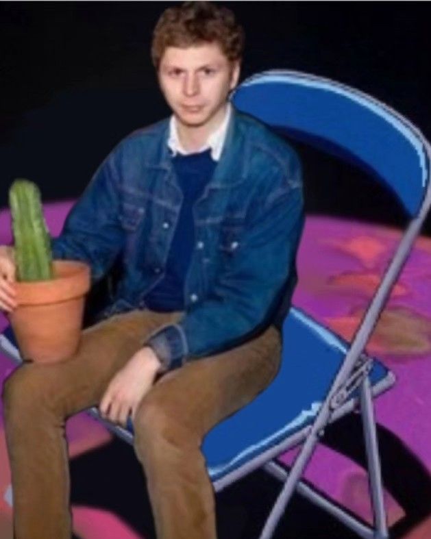 a man sitting in a chair with a potted plant on his lap and looking at the camera