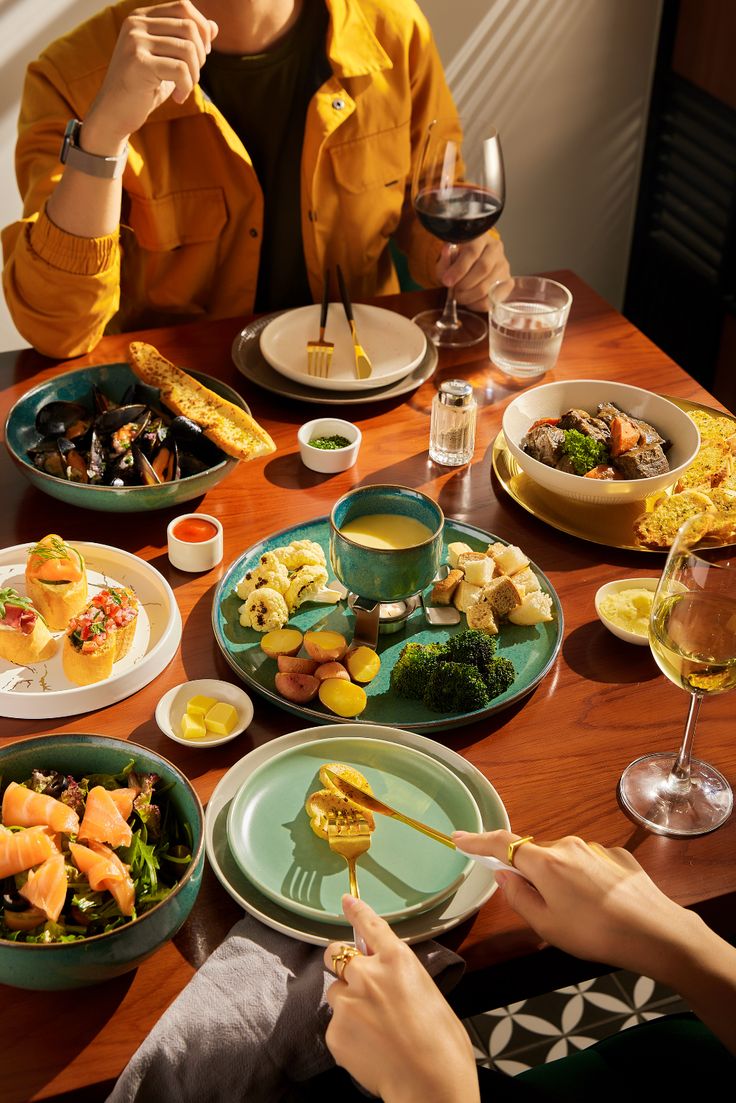 a woman sitting at a table with plates of food