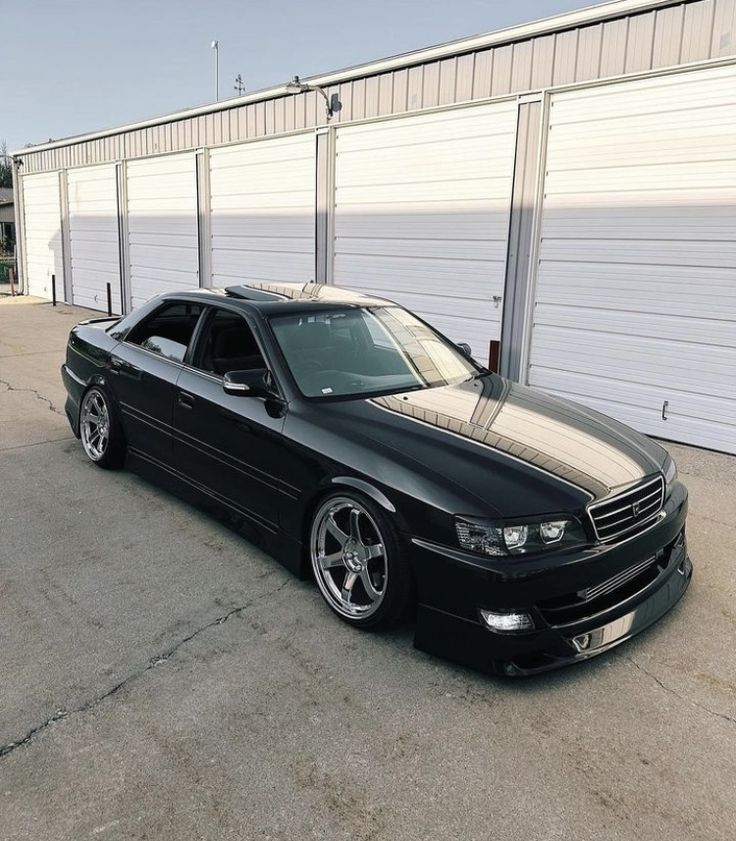 a black car parked in front of a garage