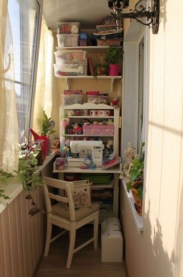 a sewing machine sitting on top of a wooden table next to a window filled with potted plants