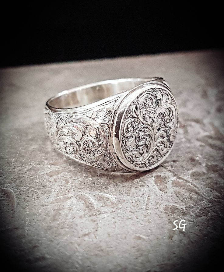 Heavy 10 karat white gold signet ring. 12 millimeters diameter at the top. Currently a size 9, weighing 11 grams, but can be made to size.  Hand engraved with a relief style, deep enough for a durable long lasting pattern. Vintage Sterling Silver Engraved Signet Ring, Vintage Engraved Sterling Silver Signet Ring, Luxury Silver Signet Ring For Formal Occasions, Elegant Silver Engraved Ring Stamped 14k, Formal Oval Engraved Ring With Etched Details, Heirloom Style White Gold Dome Ring In Sterling Silver, Heirloom Sterling Silver White Gold Dome Ring, Classic Silver Signet Ring For Formal Occasions, Silver Classic Signet Ring For Formal Occasions