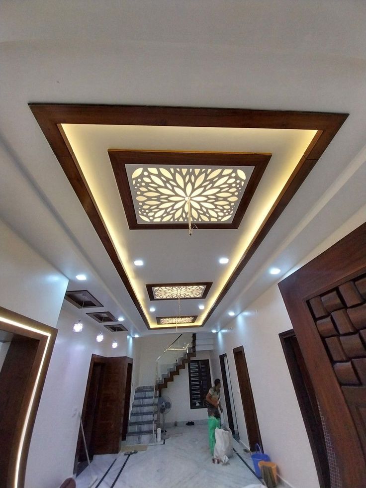 the inside of a house with some lights on and wood trimming around the ceiling