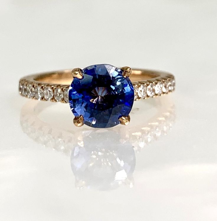 a blue sapphire and diamond ring on a white surface