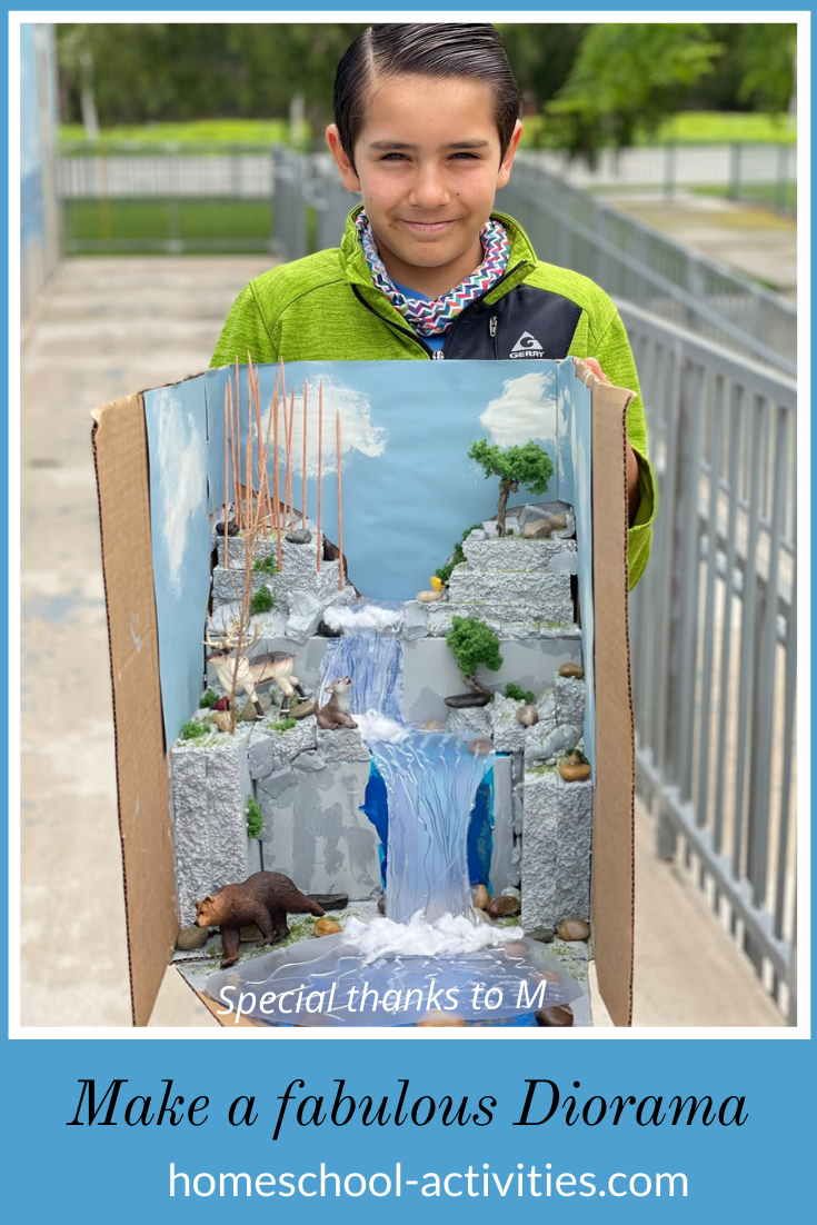 a young boy holding up a painting with the words make a fabulous diorama