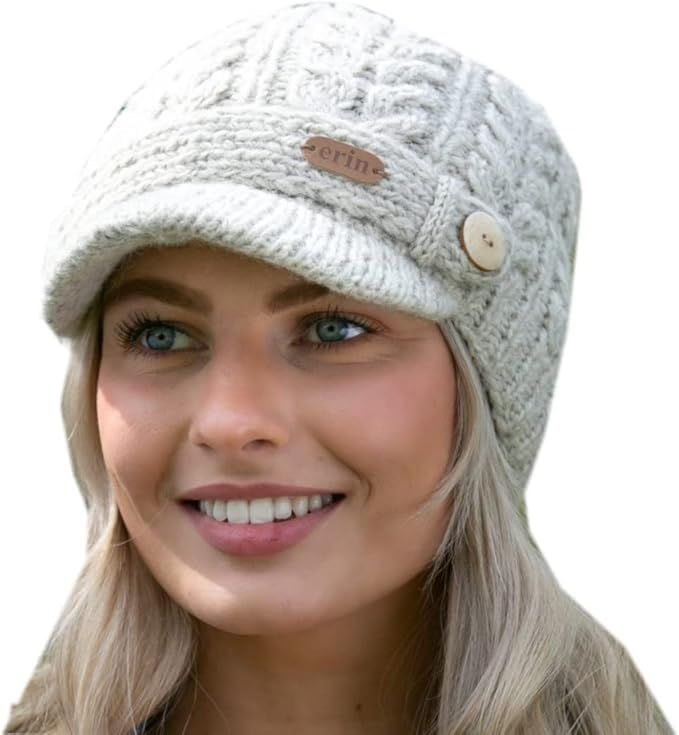 a woman with blonde hair wearing a white knitted hat and smiling at the camera