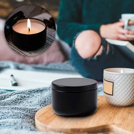 a person sitting on a bed next to a candle and cup with a tea light in it