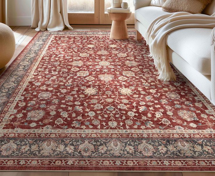 a living room with a large red rug on the floor next to a white couch