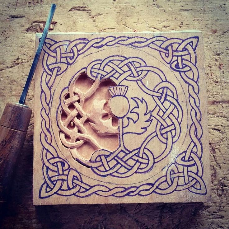 a wooden block with an intricate design on it and a toothbrush in the middle