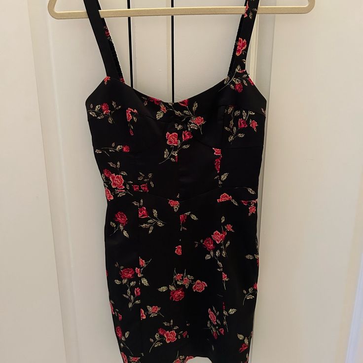 a black and red floral dress hanging on a rack