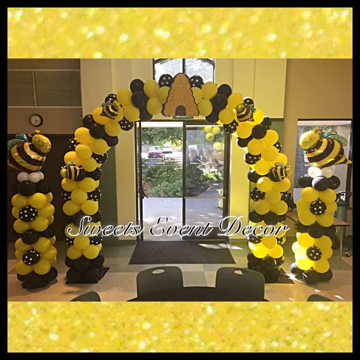 an entrance decorated with yellow and black balloons, bees and honeycombs for a bee themed party