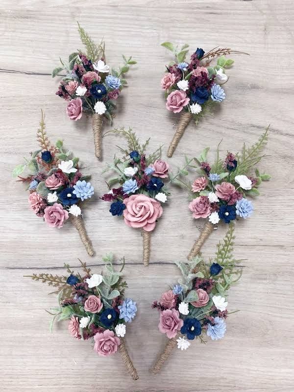 six small bouquets of flowers are arranged on a wooden surface