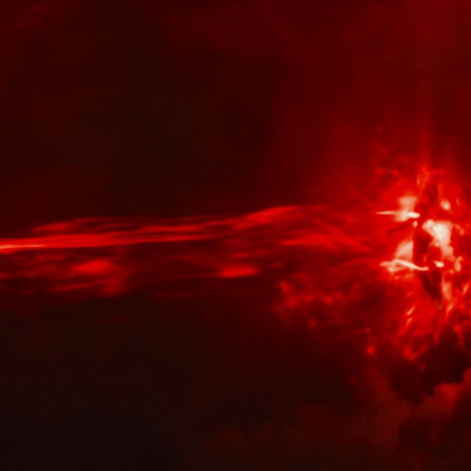 an image of the sun taken from space with red light and clouds in the background