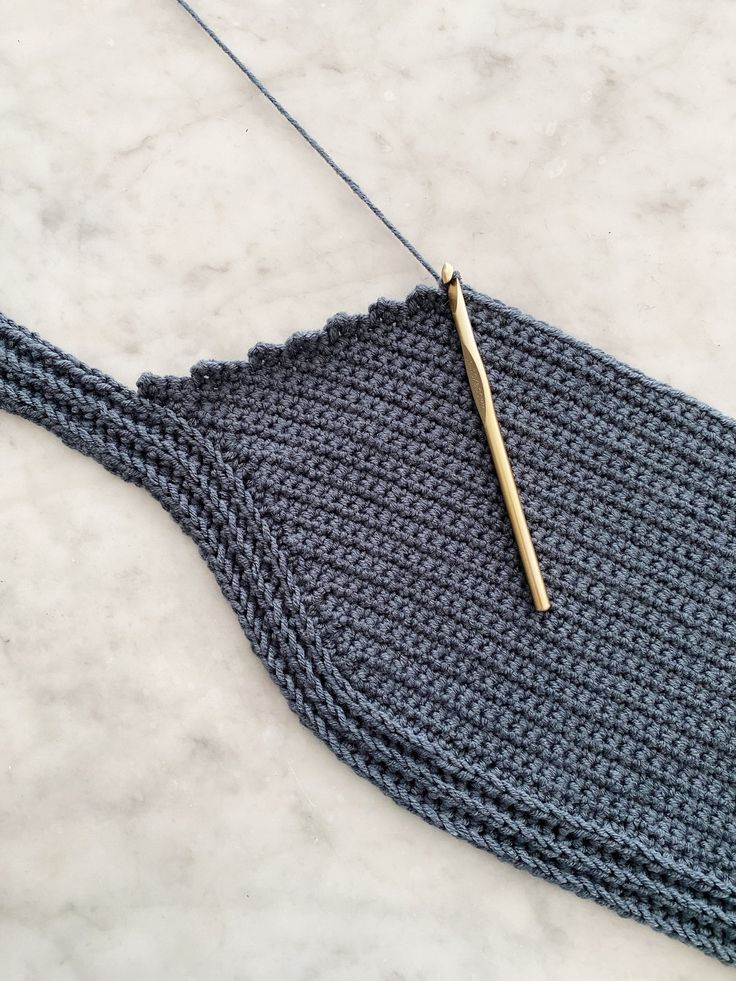 a knitted piece of cloth with a knitting needle resting on the end of it