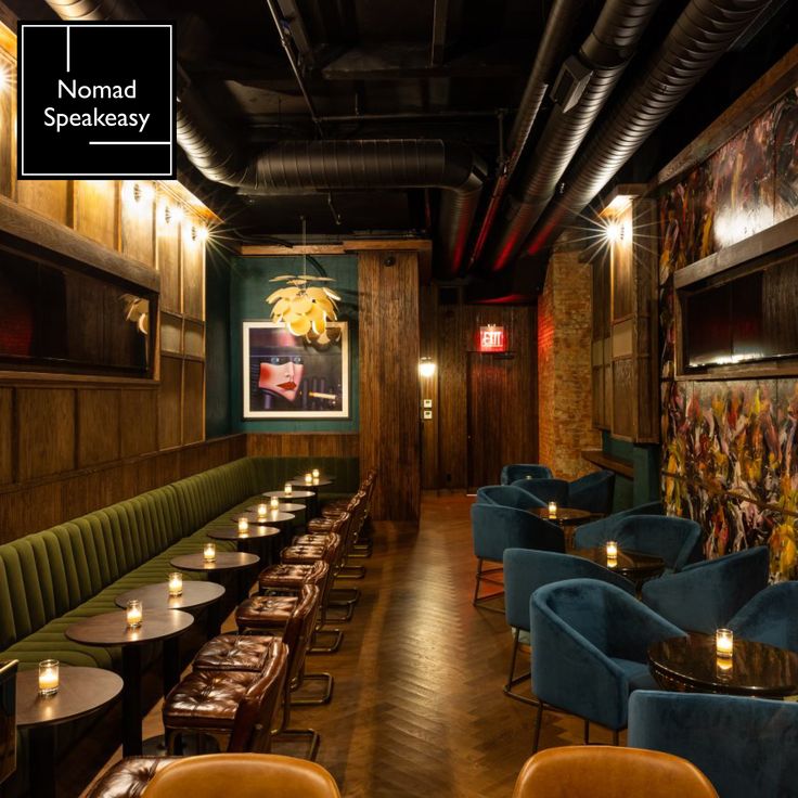 an empty restaurant with blue velvet booths and wooden walls, lit by candlelight candles