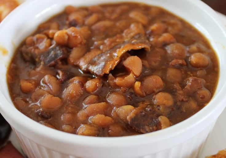 a white bowl filled with beans and meat