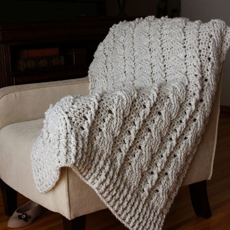 a white blanket sitting on top of a chair