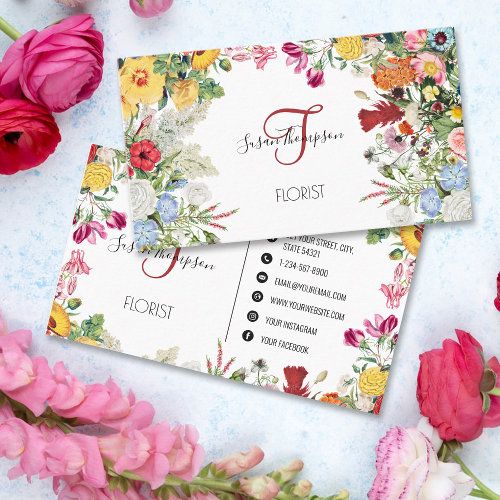 two business cards with flowers on them sitting next to some pink and yellow flowers in the background