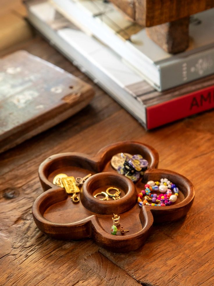 three wooden heart shaped trinkets sitting on top of a table next to a stack of books