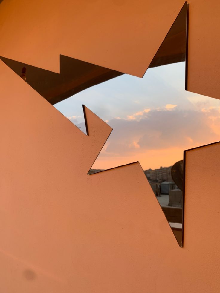 an image of a star cut out of the side of a building with a sky in the background