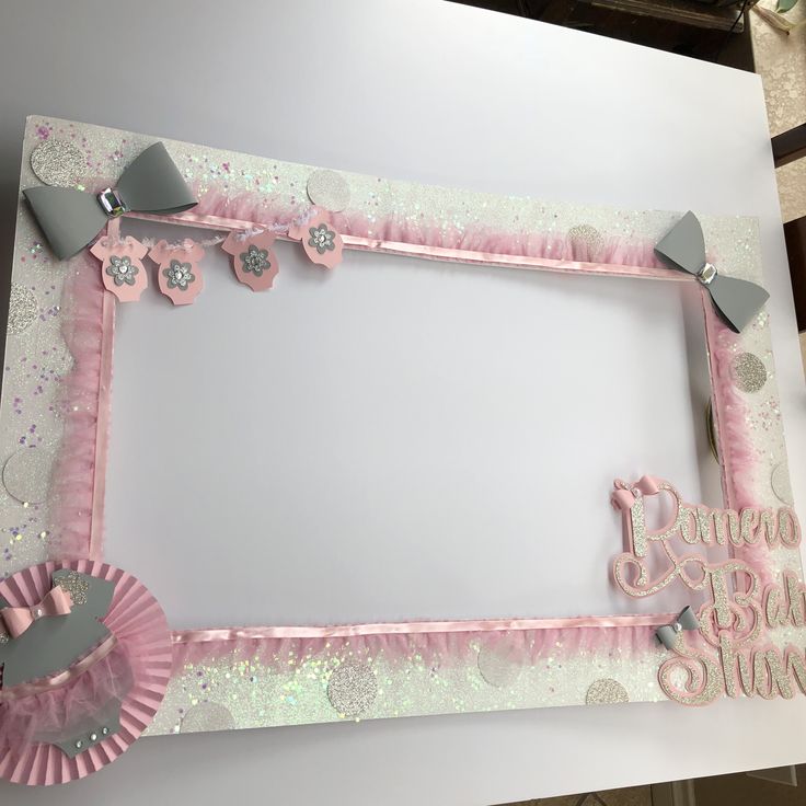 a pink and silver photo frame with some decorations on it