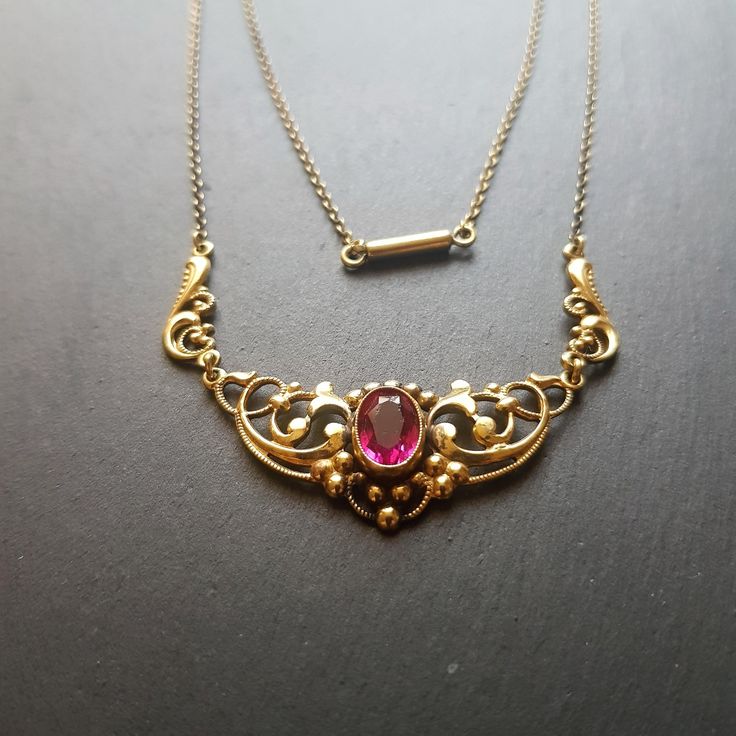 Antique Art deco brass gilded necklace  with fuschia glass faceted center stone Piece shows signs of tarnish and wear, glass stone has flee bites, see picture Length 42 cm Ornate Yellow Gold Necklace With Jewels, Antique Yellow Gold Jeweled Necklaces, Antique Yellow Gold Necklaces With Jewels, Victorian Jeweled Necklaces For Formal Occasions, Antique Pendant Necklace For Formal Occasions, Victorian Jeweled Pendant Necklace, Ornate Jeweled Necklaces For Formal Occasions, Elegant Yellow Gold Jeweled Necklace, Antique Ruby Necklace For Formal Occasions