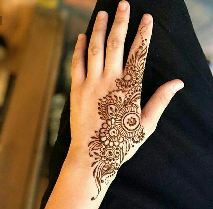 a woman's hand with henna tattoos on it